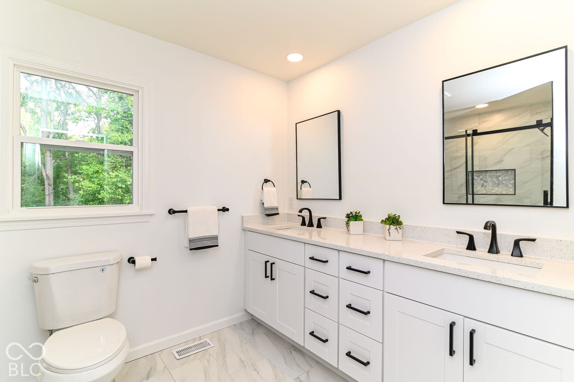 Dual vanity with white cabinetry and solid surface countertops