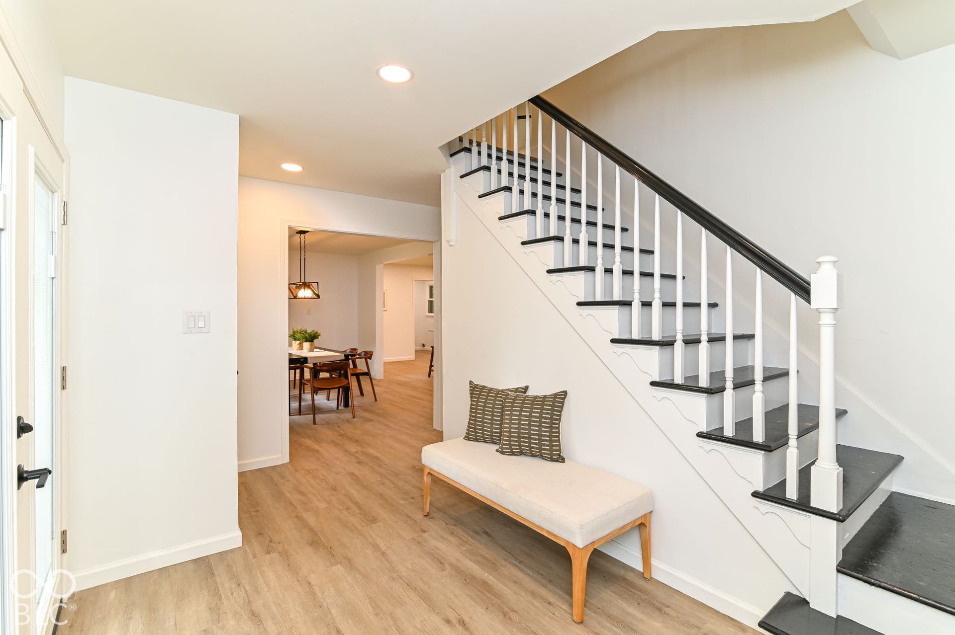 Staircase with contrasting dark treads and white risers, wood-finish flooring, recessed lighting, and white walls
