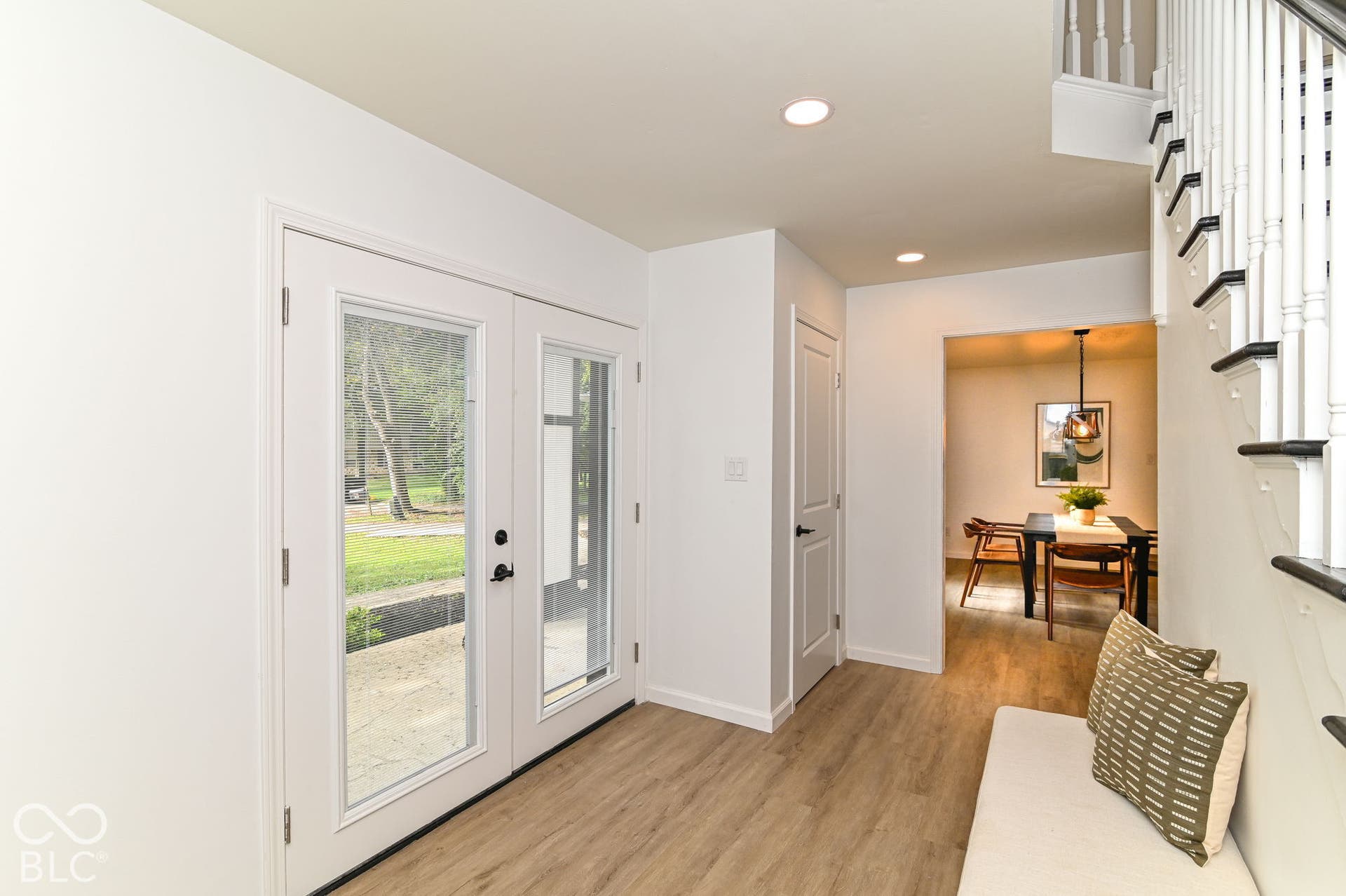 Entryway with wood-finish flooring, recessed lighting, and a white baluster staircase