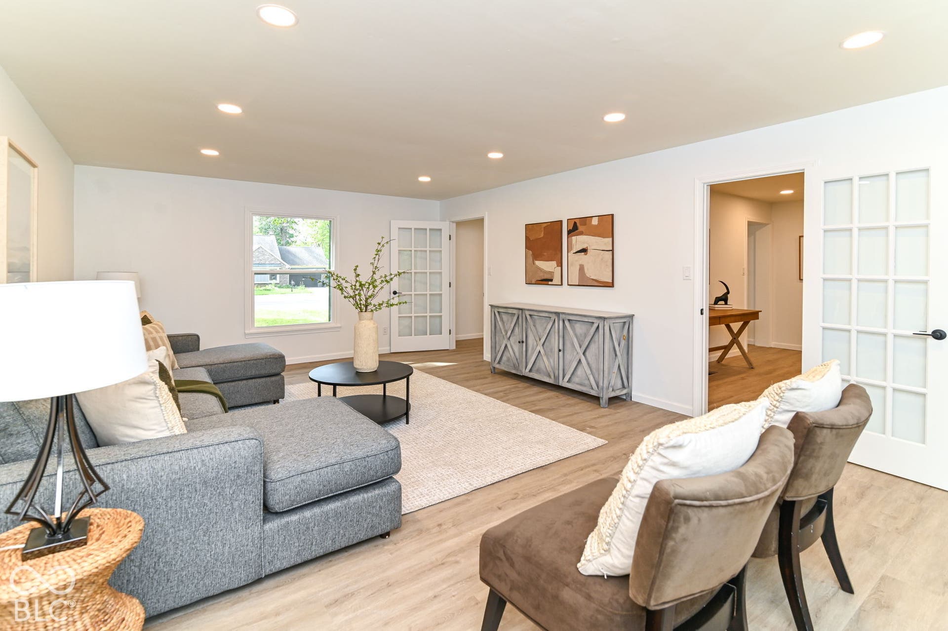 Recessed ceiling lighting, light wood-finish flooring, white walls, and French doors