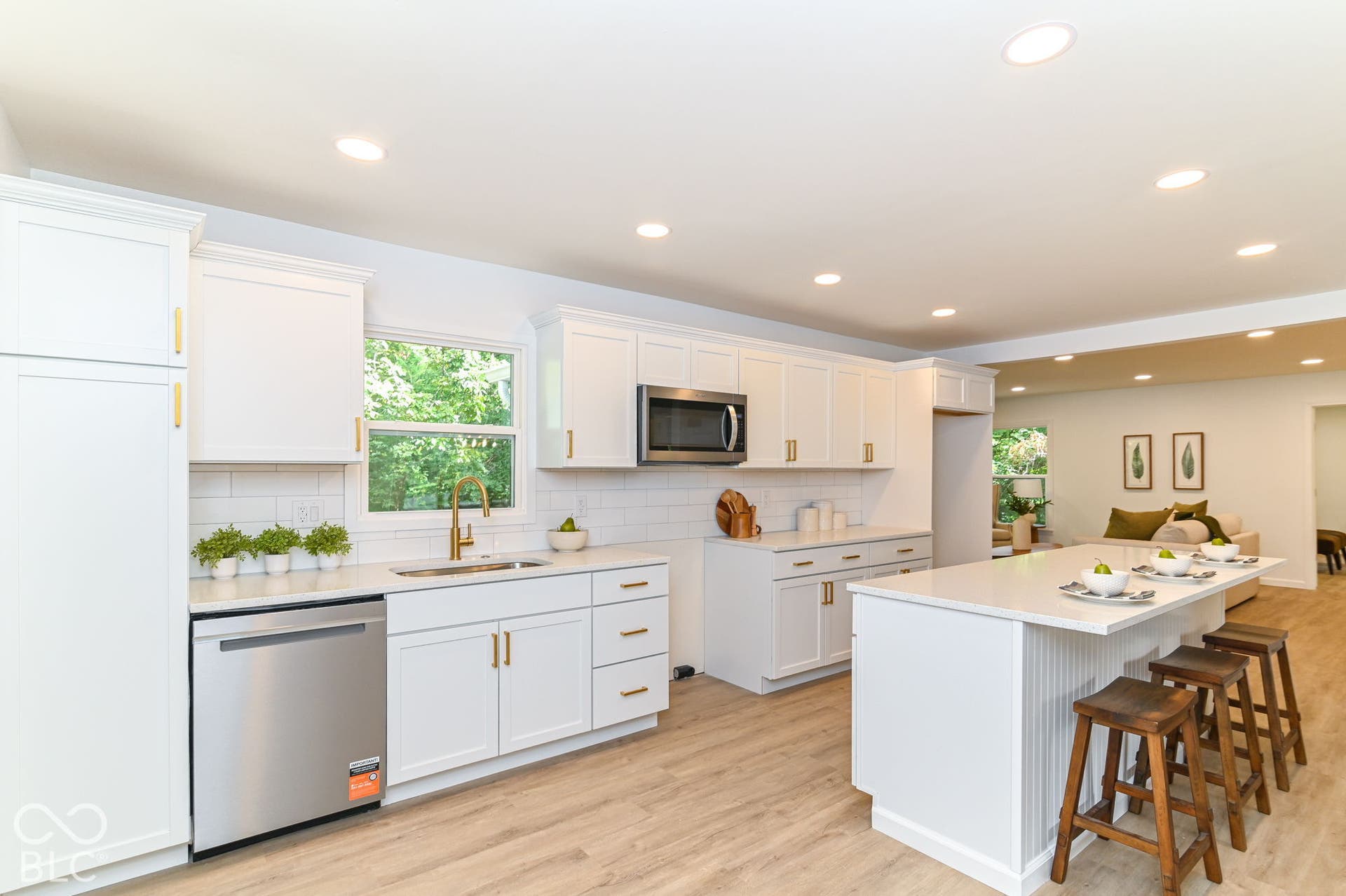 White shaker cabinetry with gold-finish hardware, stainless steel dishwasher, wood-finish flooring, white subway tile backsplash, and recessed lighting
