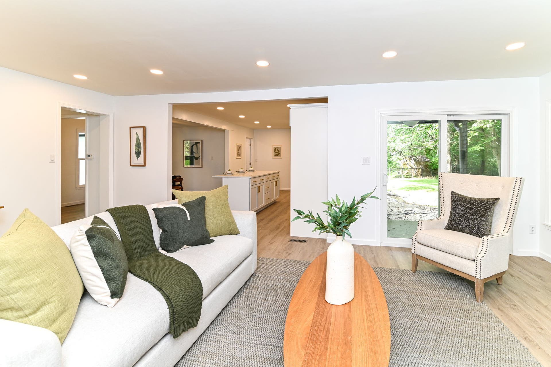 Recessed lighting, wood-finish flooring, white walls, and a sliding glass door to the exterior