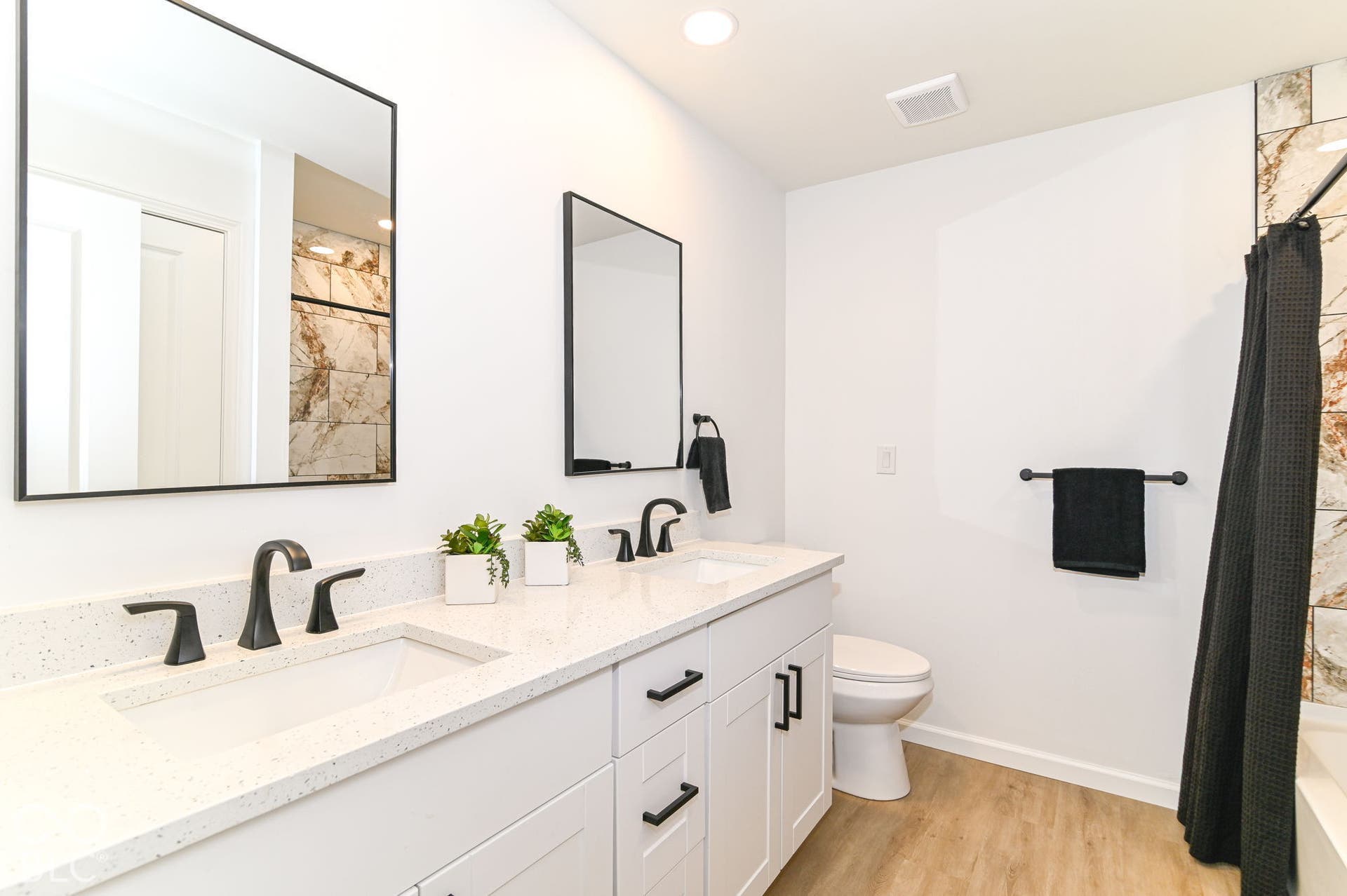 Dual vanity with white shaker-style cabinetry and matte black hardware