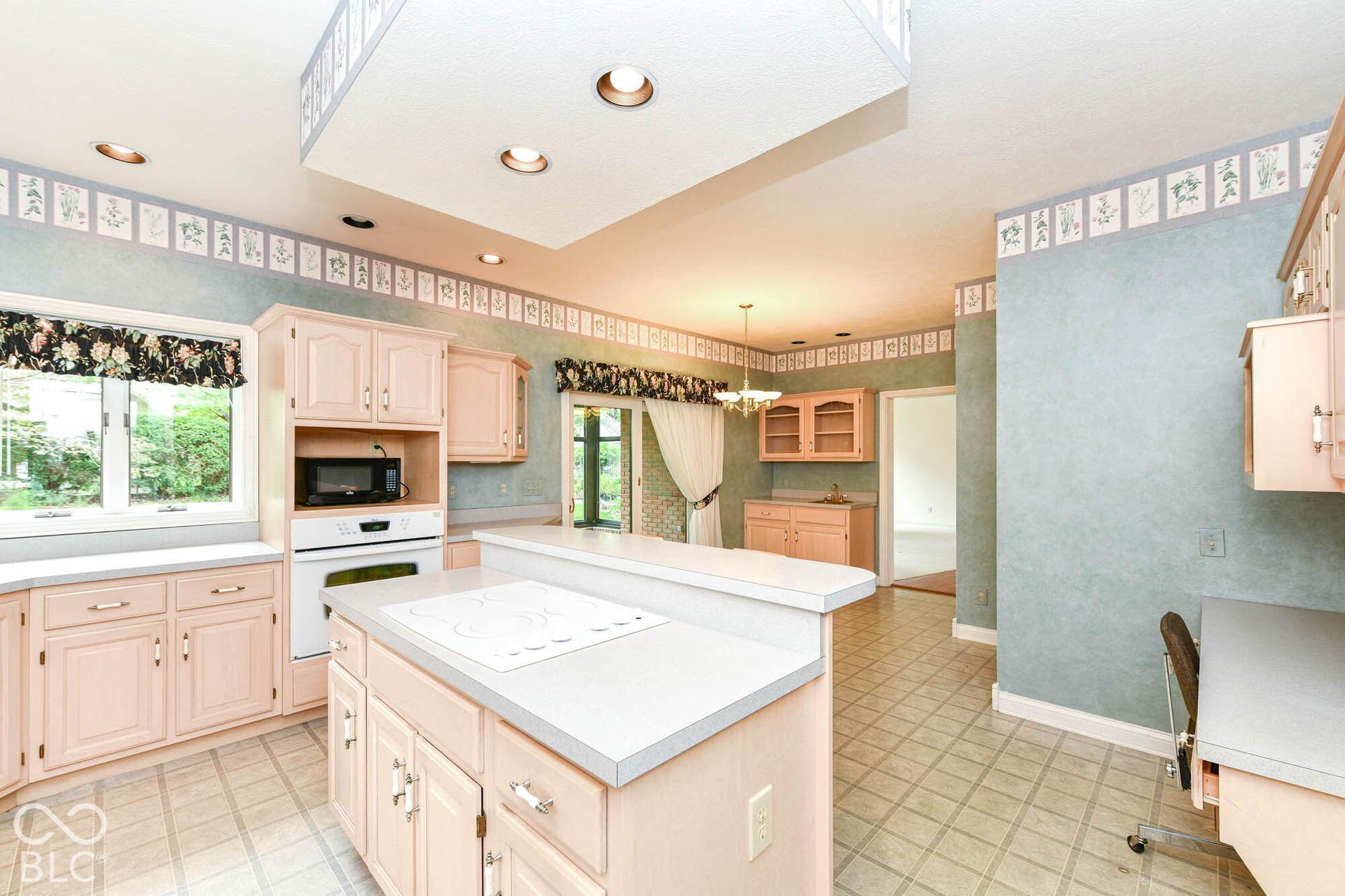 6431 Shamel Drive, Indianapolis, IN 46278 Kitchen with light-toned cabinetry and an integrated cooktop on the island