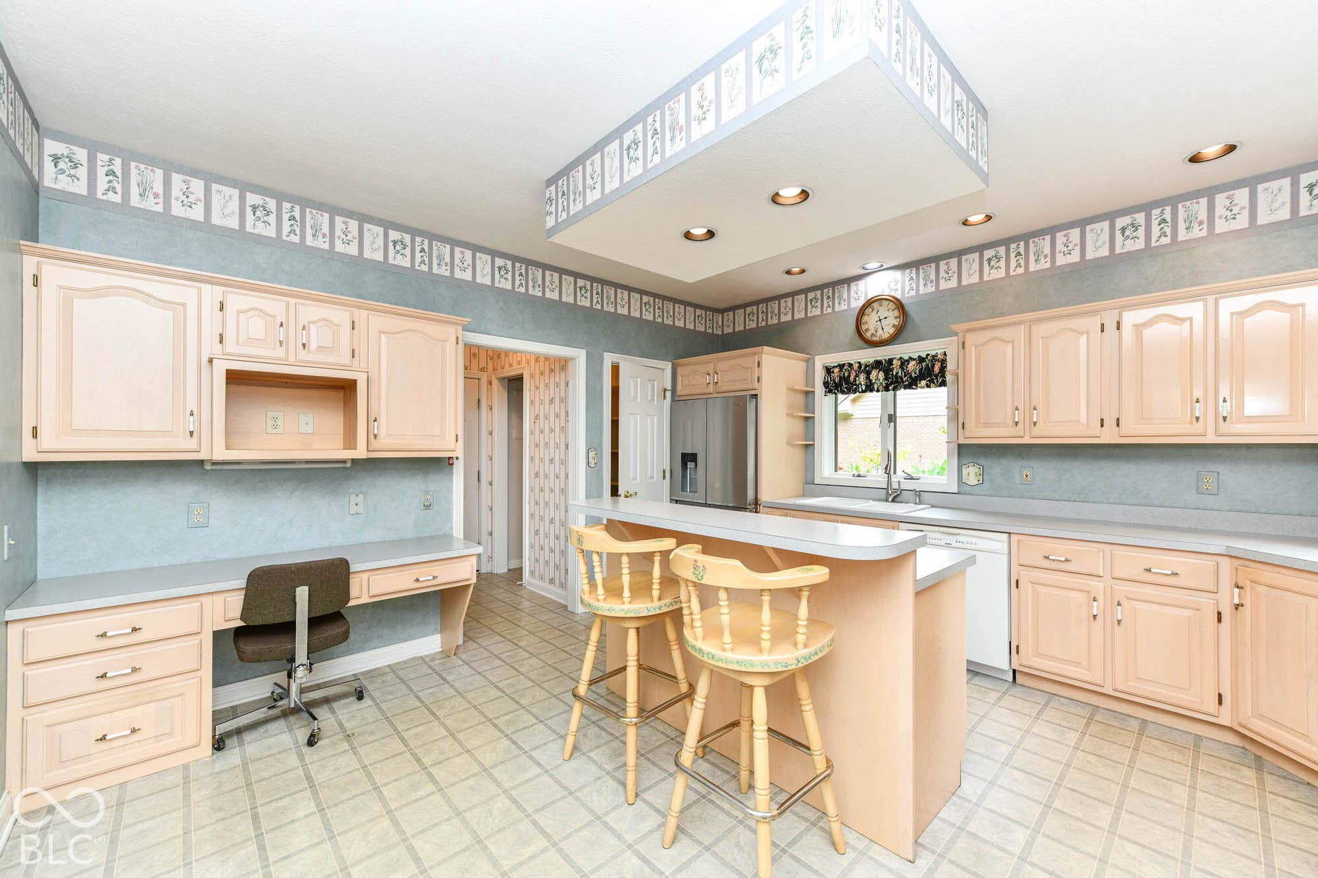 6431 Shamel Drive, Indianapolis, IN 46278 Spacious Kitchen featuring light wood-finish cabinetry, a built-in desk area, an integrated kitchen island with seating, a stainless steel refrigerator, and recessed ceiling lighting