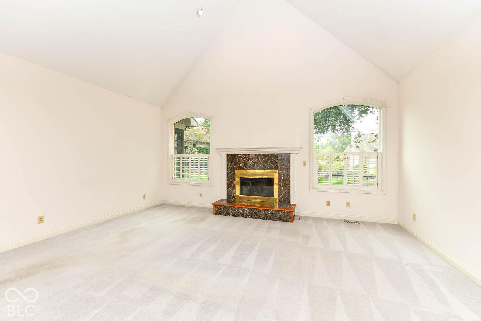 6431 Shamel Drive, Indianapolis, IN 46278 Great Room. Vaulted ceiling, arched windows, plantation shutters, fireplace with marble-style surround, brass firebox and wood mantel