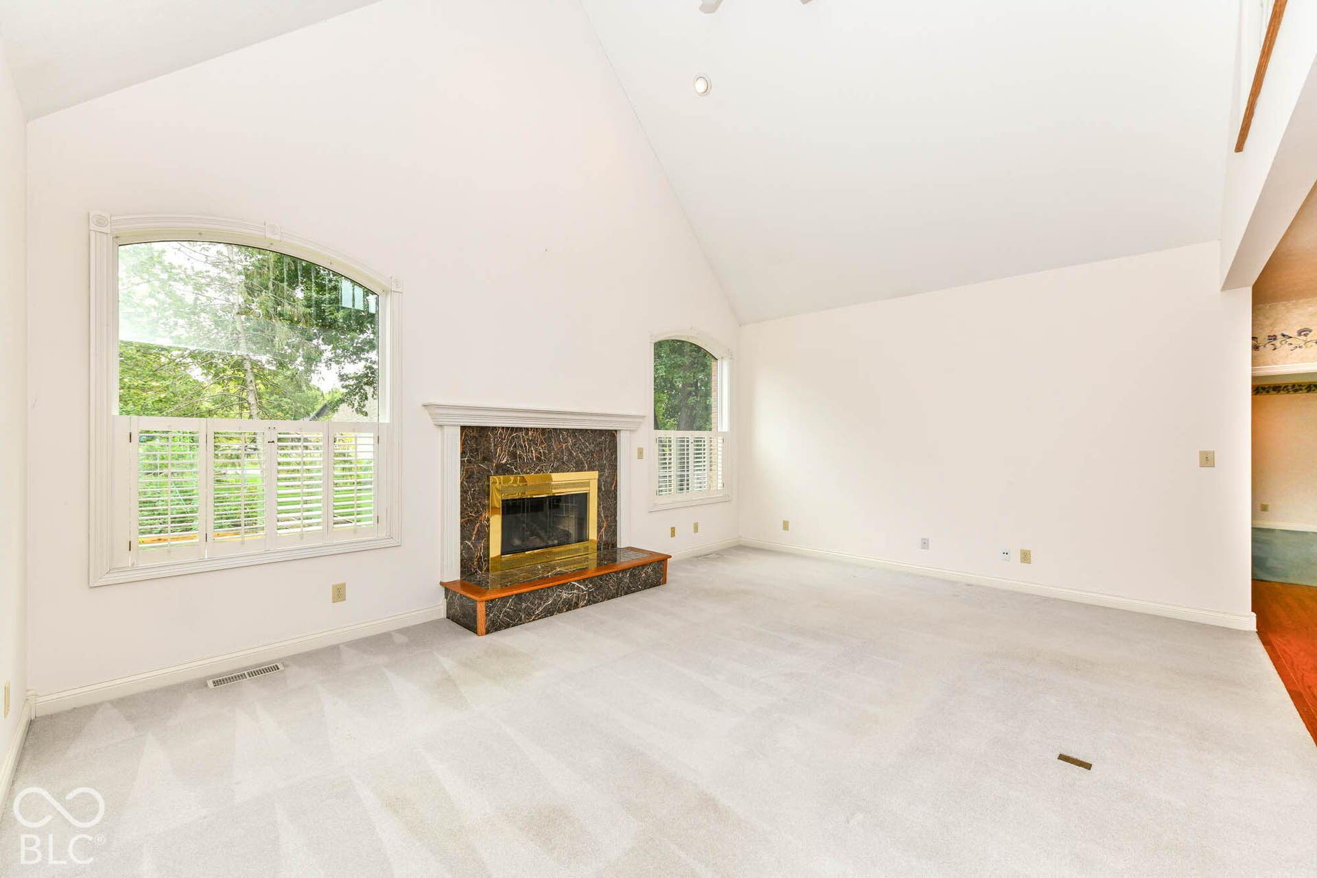 6431 Shamel Drive, Indianapolis, IN 46278 Vaulted ceiling, arched windows, plantation shutters, fireplace with marble-style surround, brass firebox and wood mantel