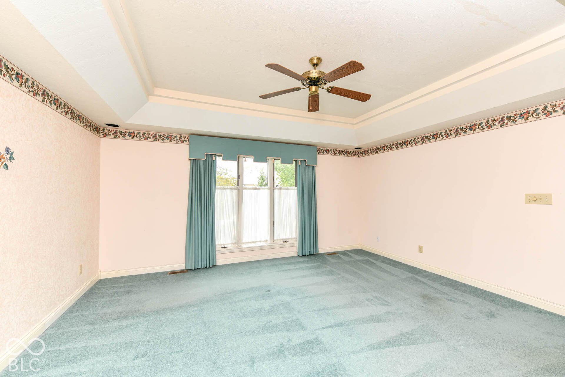 6431 Shamel Drive, Indianapolis, IN 46278 Main floor Primary Bedroom. Tray ceiling with a ceiling fan, wall-to-wall carpeting and a large window with valance
