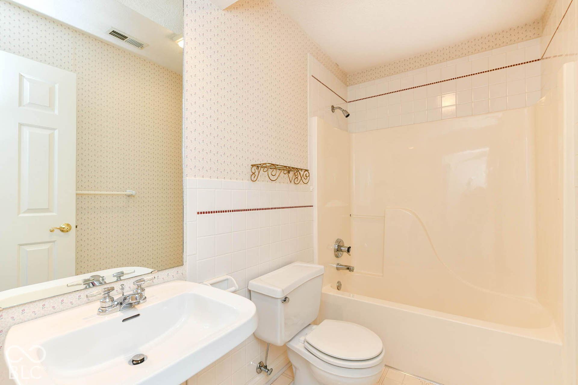 6431 Shamel Drive, Indianapolis, IN 46278 Upper Full Bathroom. Wall-mounted vanity sink, wall-to-wall mirror, built-in bathtub, and tiled shower surround