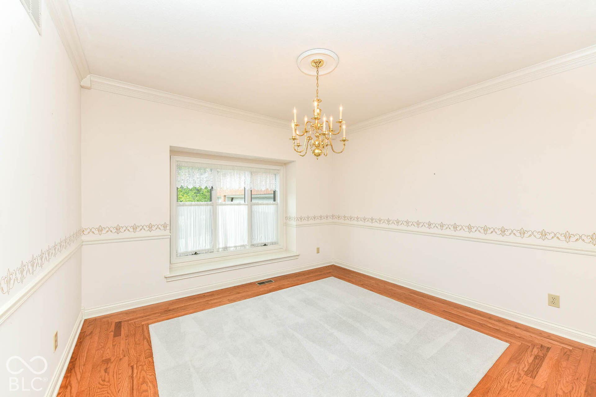 6431 Shamel Drive, Indianapolis, IN 46278 Dining Room. Hardwood flooring, decorative crown molding, recessed window, and an ornate chandelier