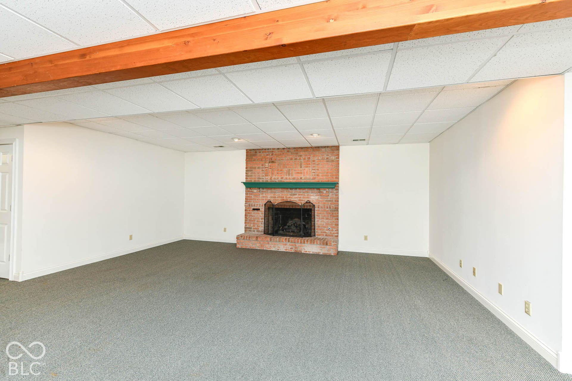 6431 Shamel Drive, Indianapolis, IN 46278 Basement Living Area. Exposed wood beam, brick gas fireplace, recessed lighting, and a drop ceiling