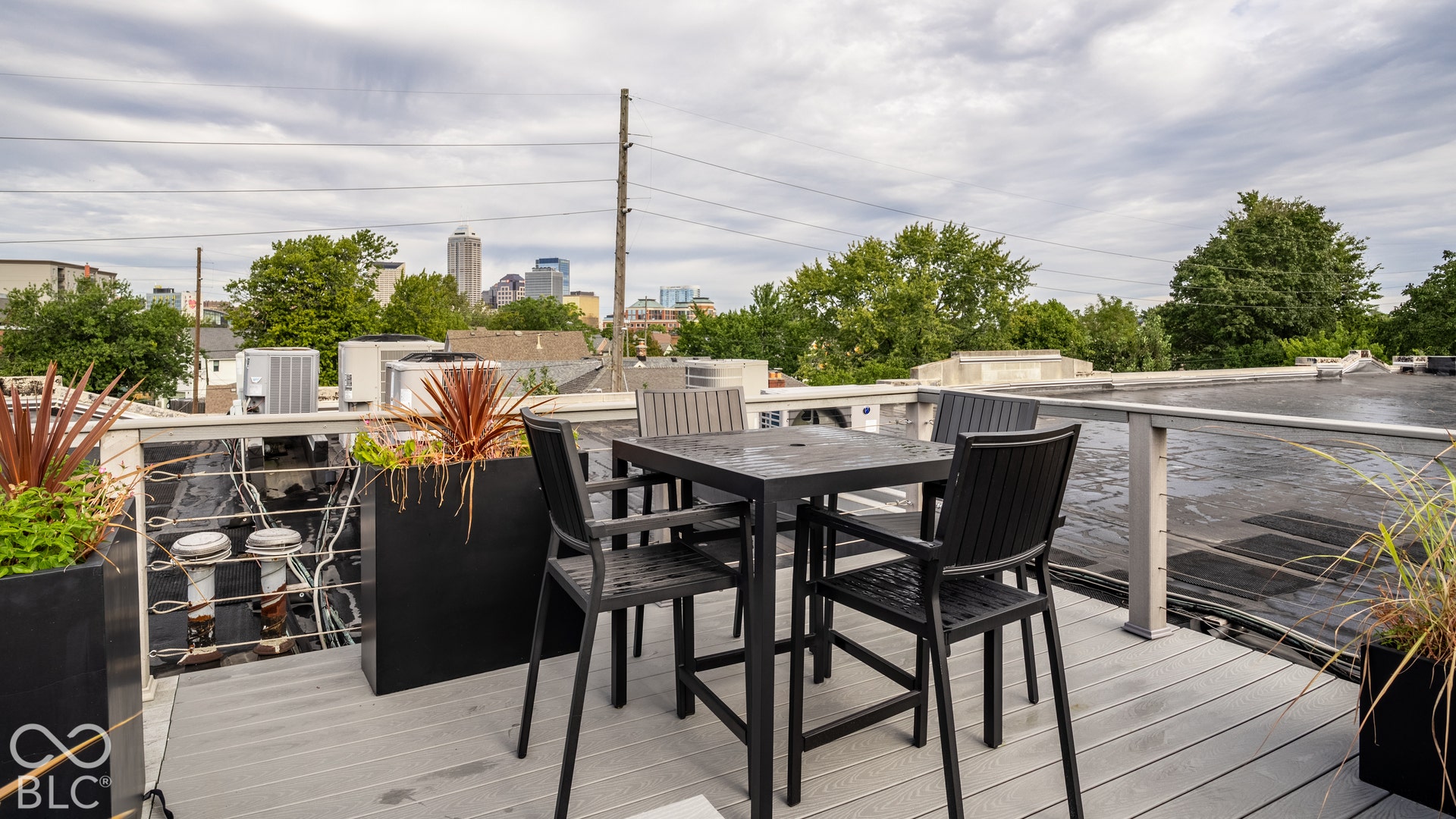 Rooftop deck featuring composite decking, metal railings, and city skyline in the distance