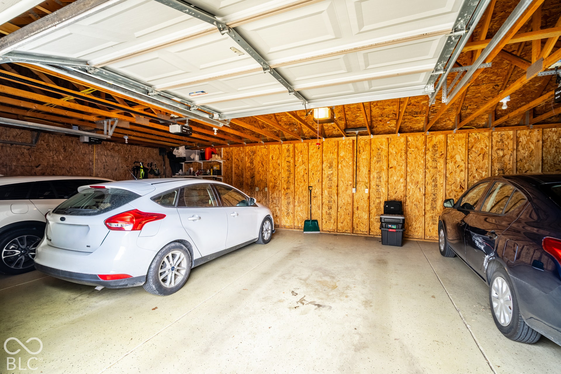 Concrete flooring, exposed wood framing, and overhead lighting