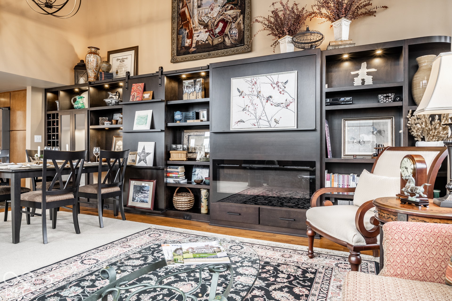 Custom built-in shelving with integrated lighting, a built-in fireplace, and a barn door detail