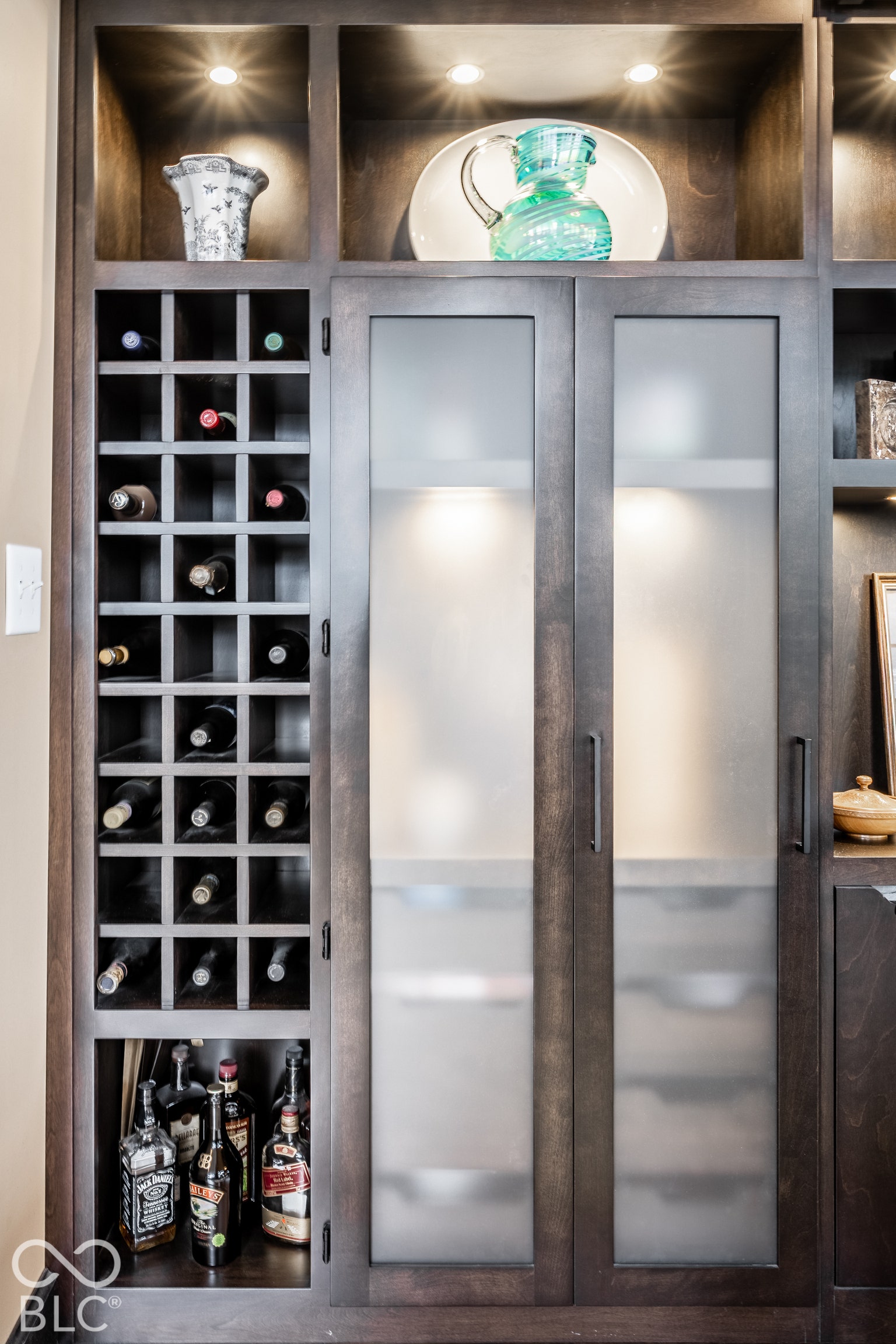 Built-in cabinetry with a dedicated wine rack, frosted glass doors, and integrated lighting