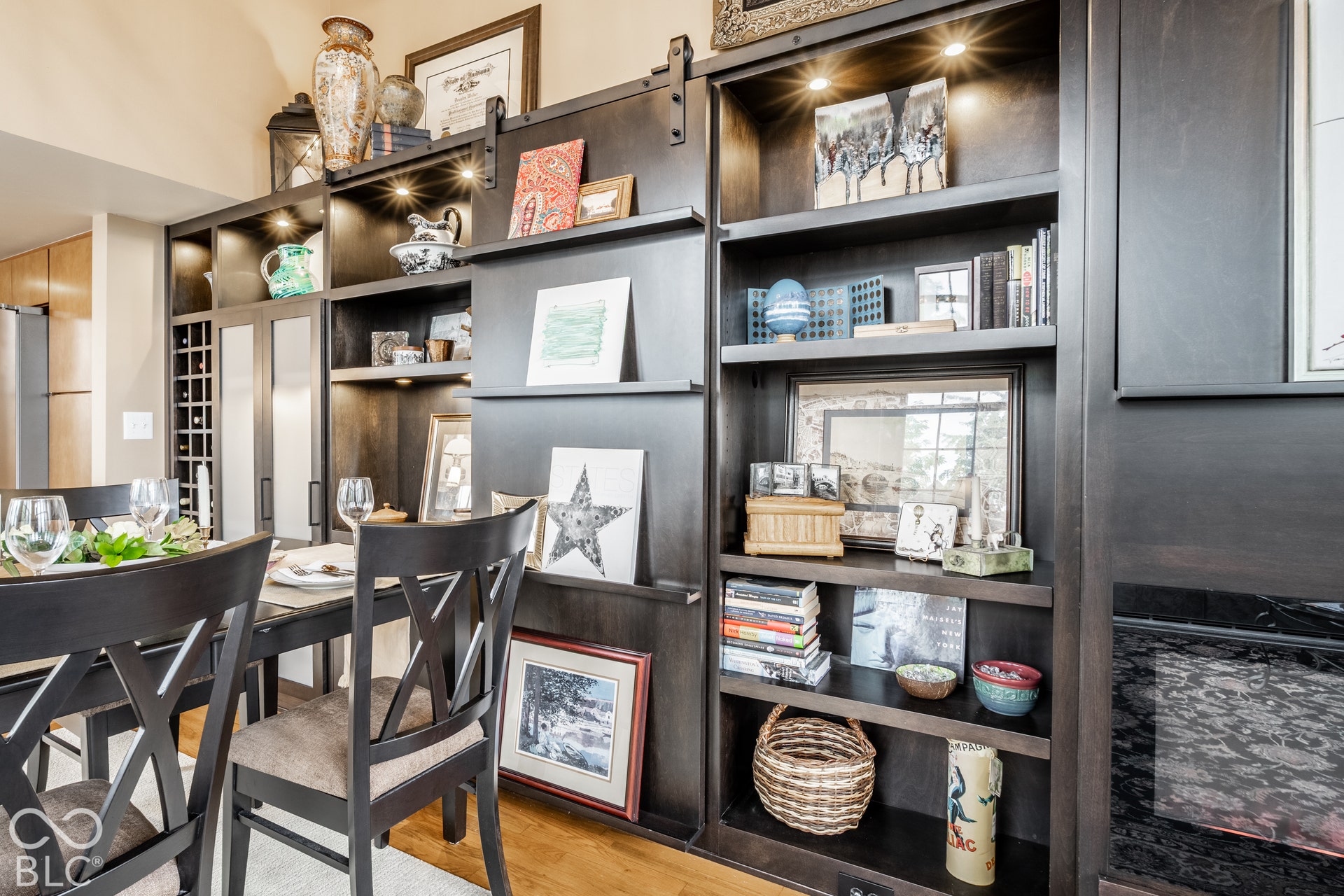 Custom built-in shelving with integrated lighting, a sliding barn door accent, and a dedicated wine rack