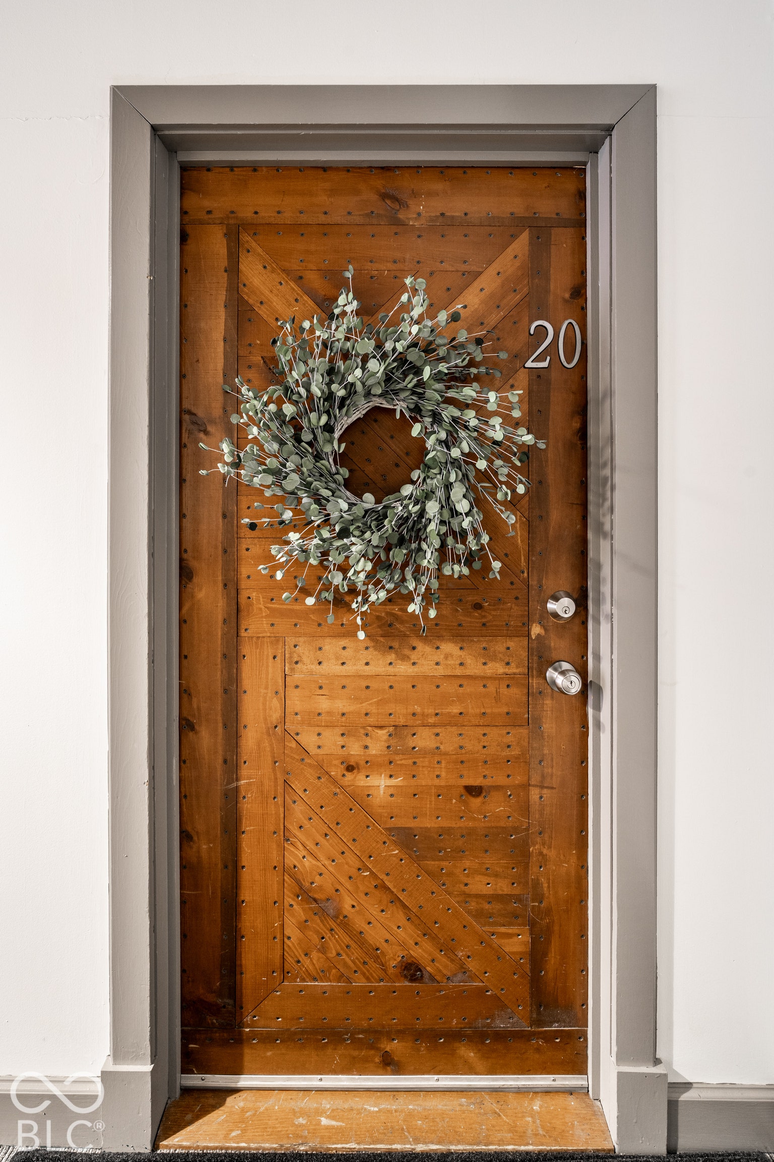 Barn-style wooden entry door with a decorative wreath