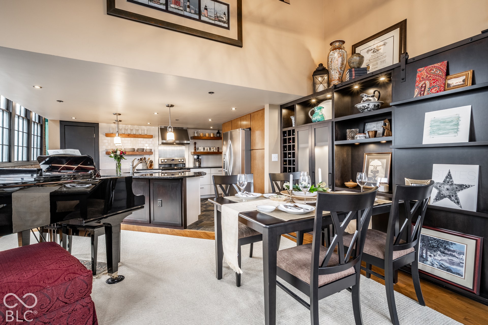 Custom built-in cabinetry with integrated lighting, a kitchen island with dark countertops, recessed ceiling lights, and wood-finish flooring