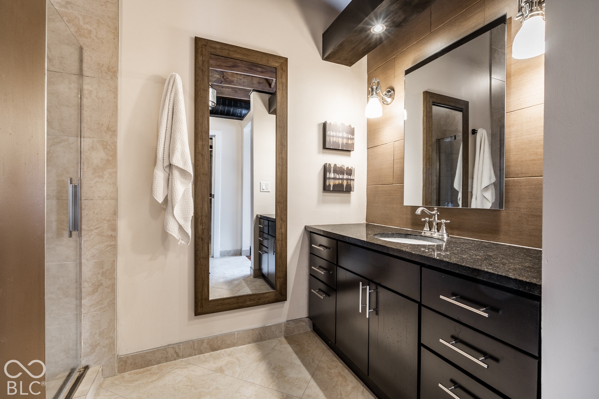 Built-in vanity with dark cabinetry, integrated sink, and dark countertop