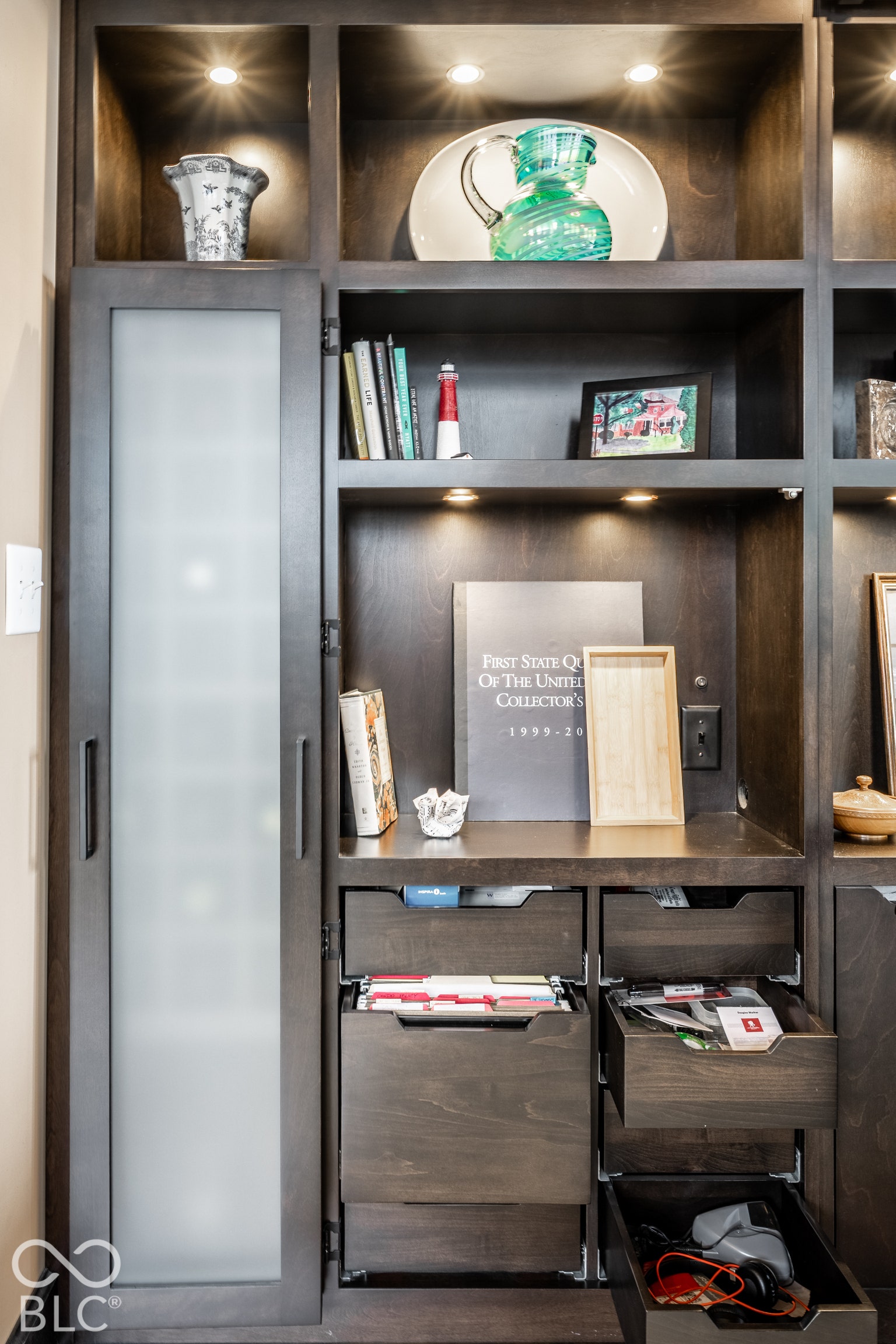 Custom built-in cabinetry featuring integrated lighting and a frosted glass-front door