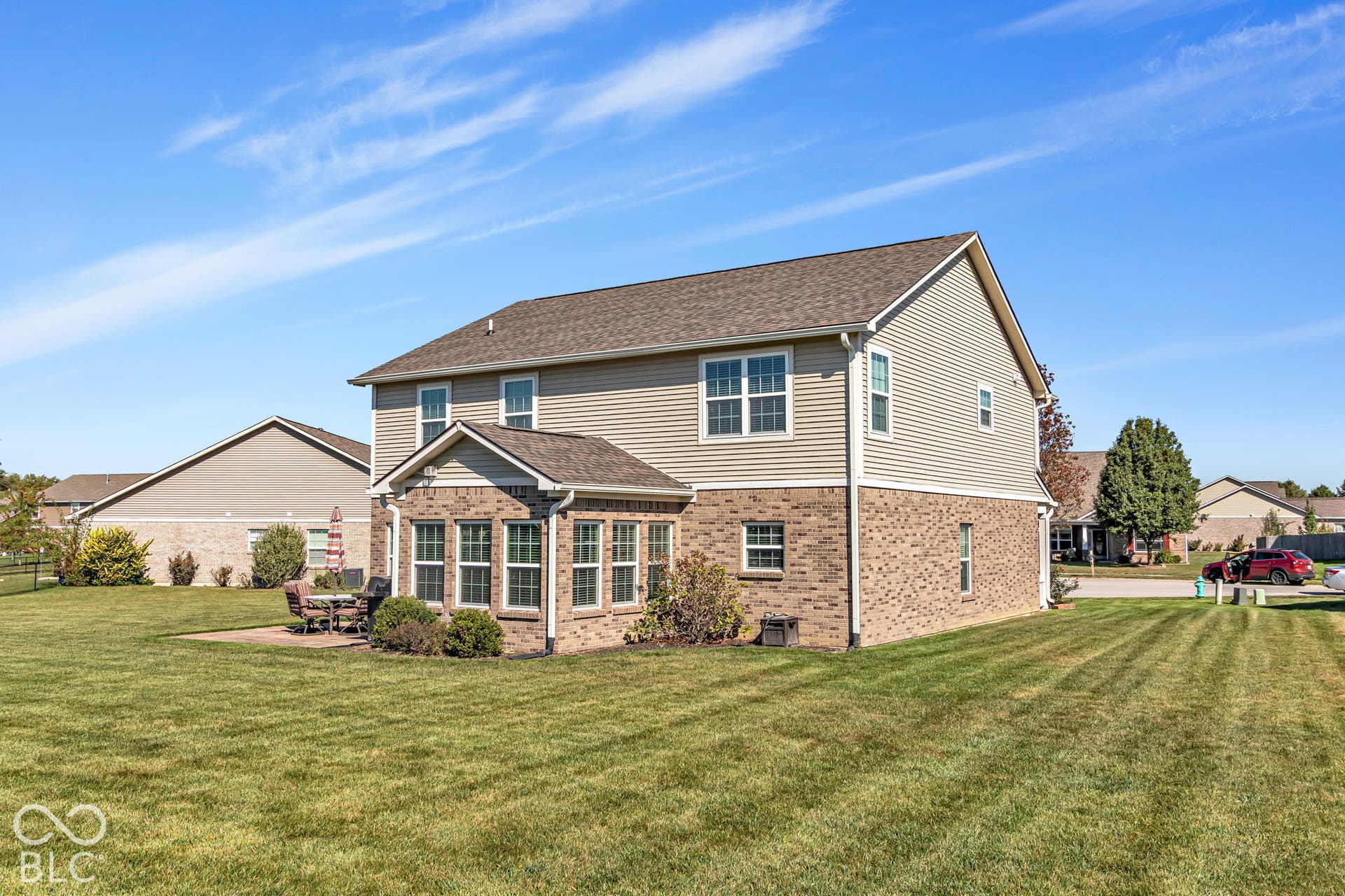 Brick and siding exterior with a sunroom addition and an outdoor patio