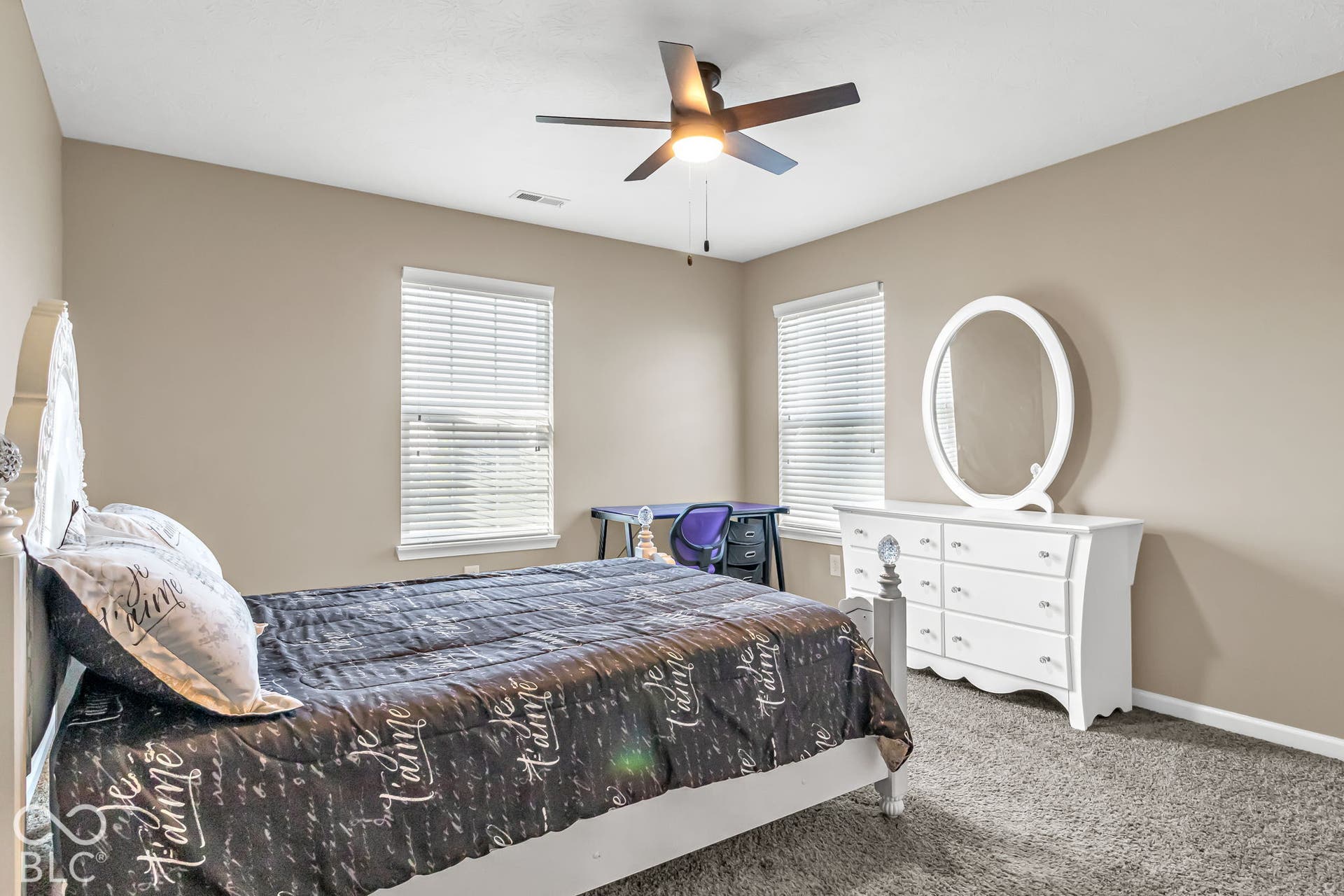 Vaulted ceiling with an attached ceiling fan, dual windows with blinds, and gray carpeting