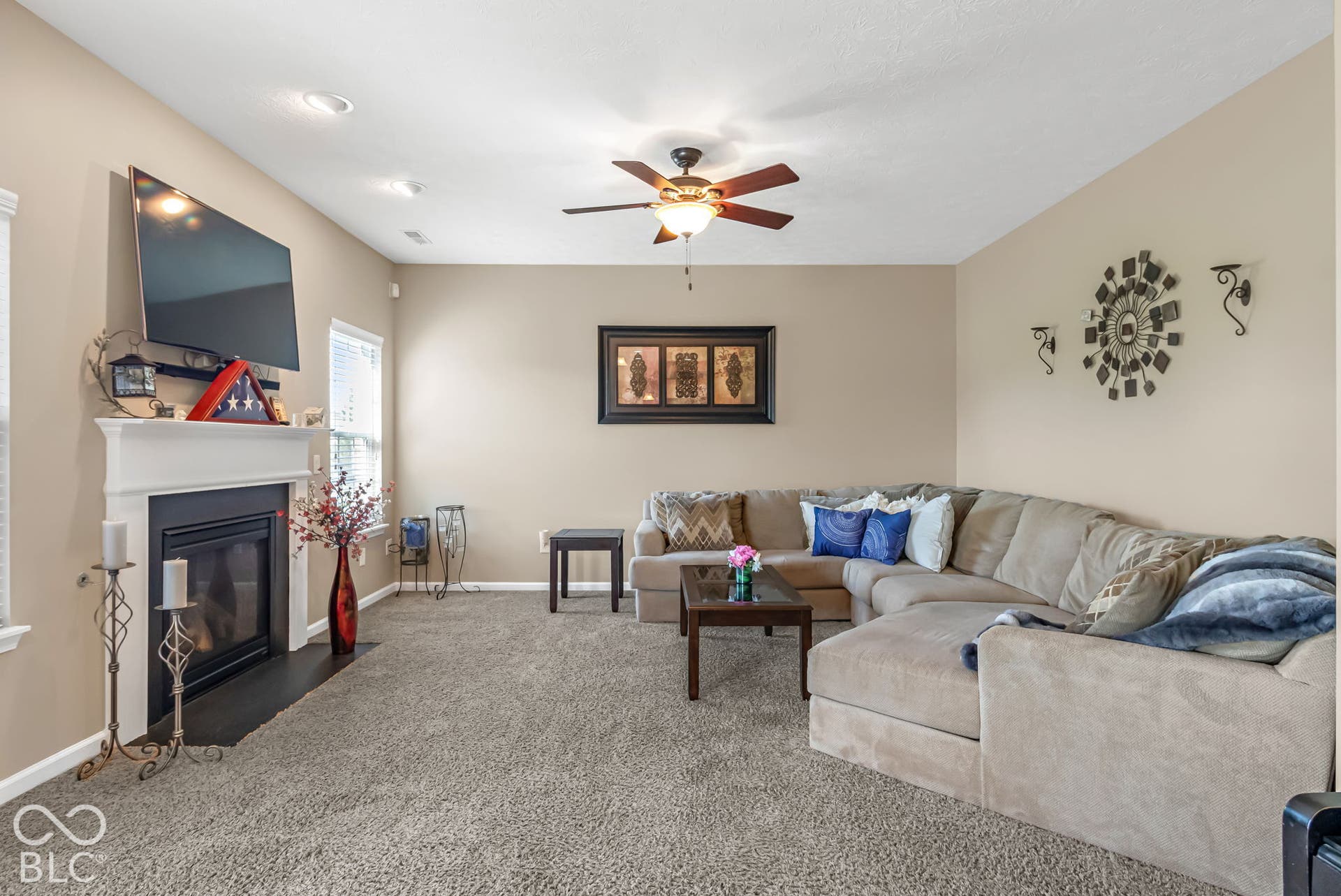 Living area with recessed lighting, an interior fireplace with white mantel, a ceiling fan, and carpeted flooring