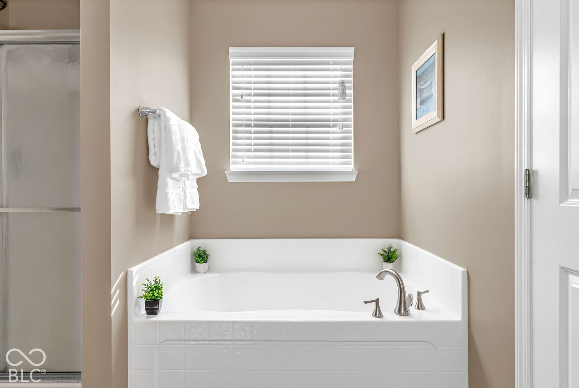 Built-in soaking tub with brushed nickel fixtures and a tiled surround