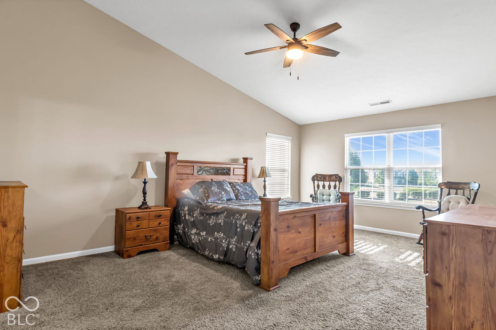 Vaulted ceiling with a ceiling fan, carpeted flooring, and window blinds