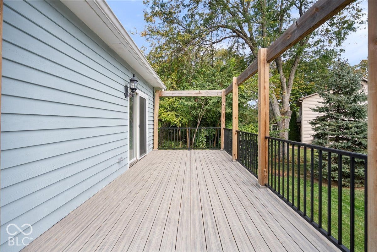 Outdoor deck featuring composite decking, timber support beams, and black metal railings