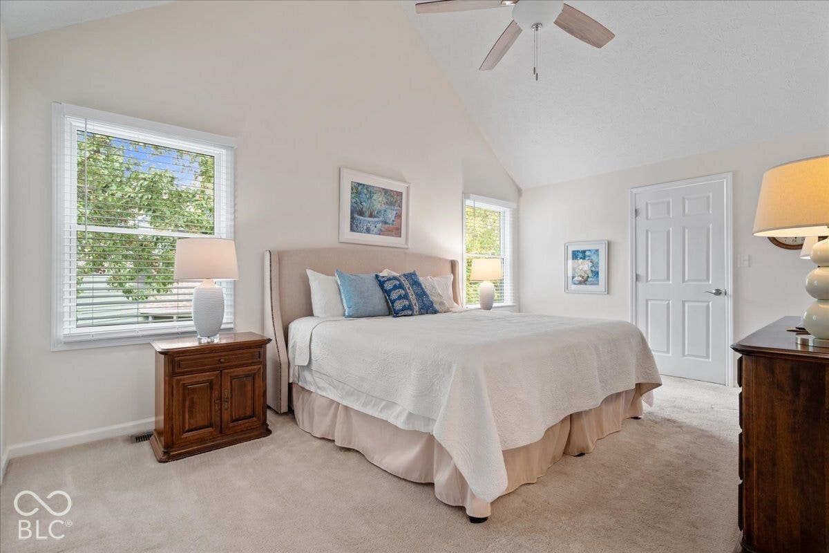 Vaulted ceilings, carpeted flooring, dual windows, and an attached ceiling fan with lighting