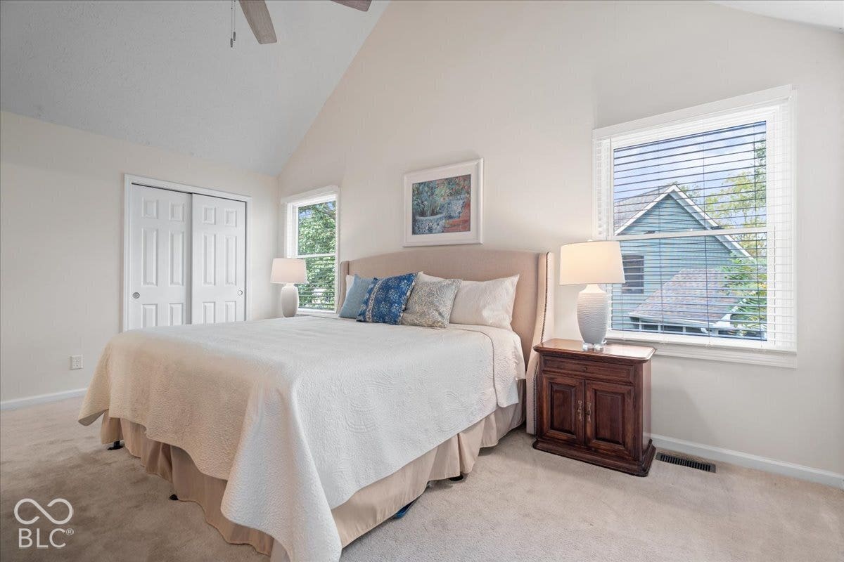 Vaulted ceiling, dual windows with integrated blinds, and sliding double-panel closet doors