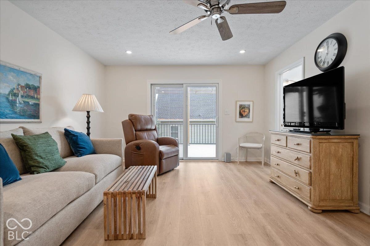 Currently used as main level family room. Featuring light laminate wood-finish flooring, recessed lighting, a ceiling fan, and sliding glass doors with exterior balcony access.  Was perfect for water color painting and puzzles!