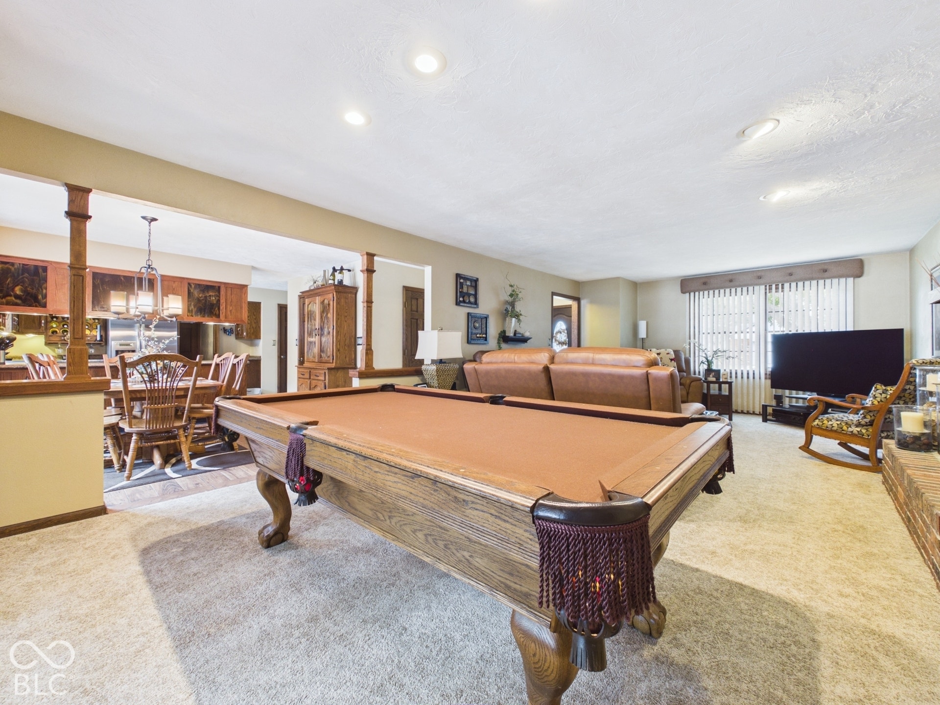 Recessed lighting, carpeted flooring, and a brick fireplace