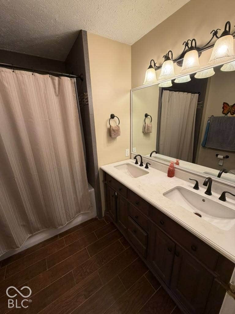 Dual vanity with integrated sinks and dark wood-finish cabinetry