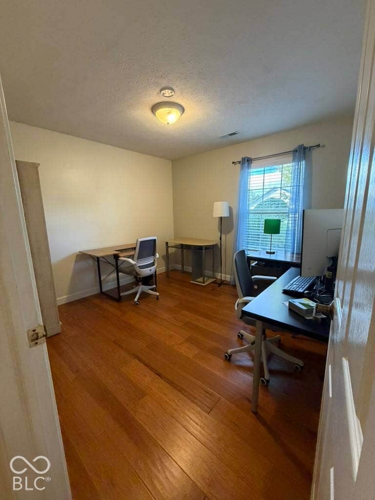 Hardwood flooring throughout, neutral wall tones, and a window with natural light