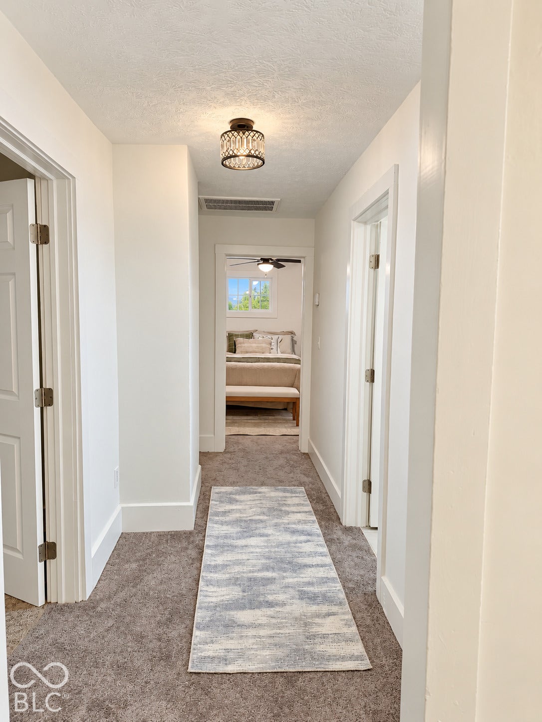 Hallway (upper level) featuring neutral wall-to-wall carpeting and crisp white door casings