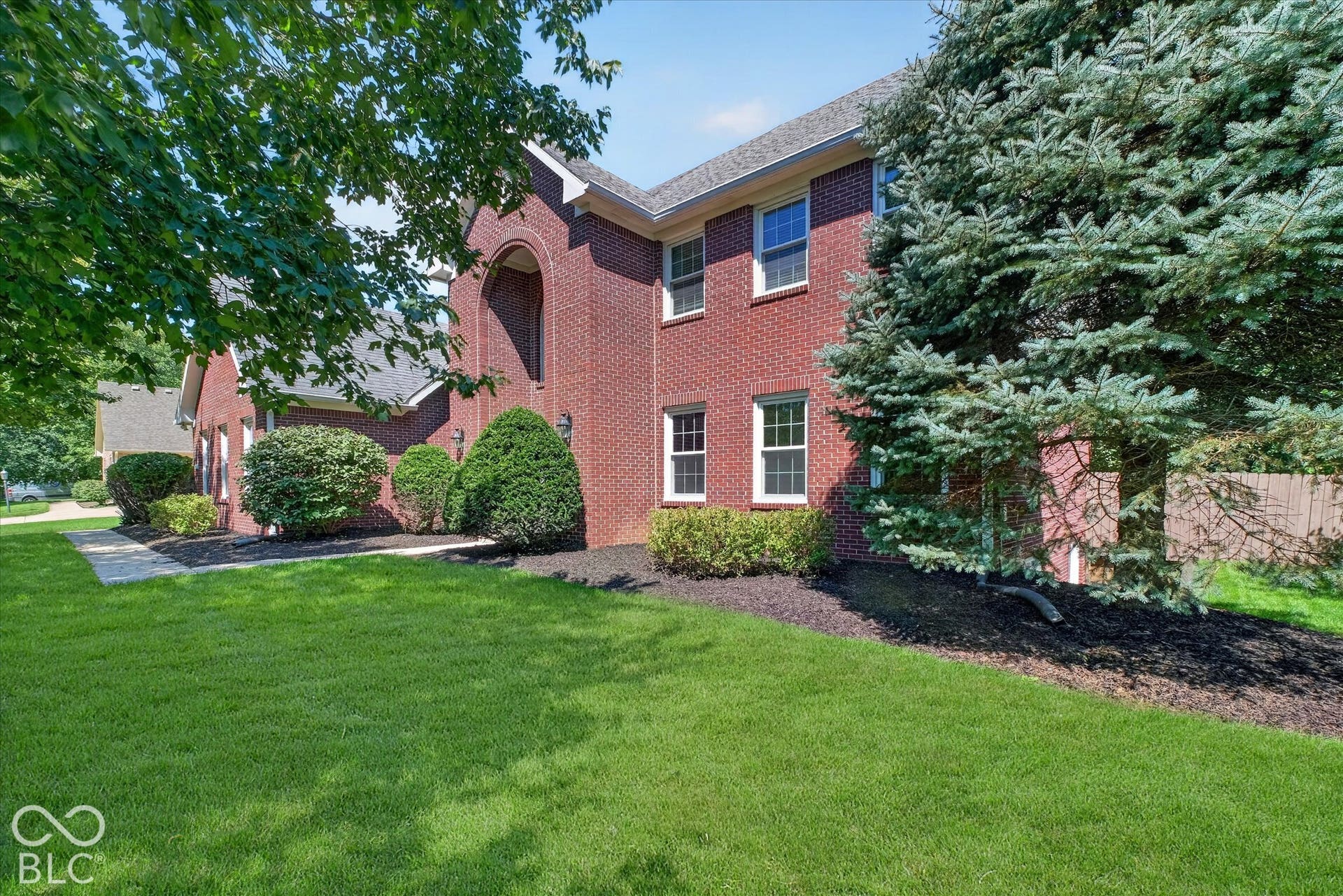 Red brick exterior with white trim windows and an arched entryway