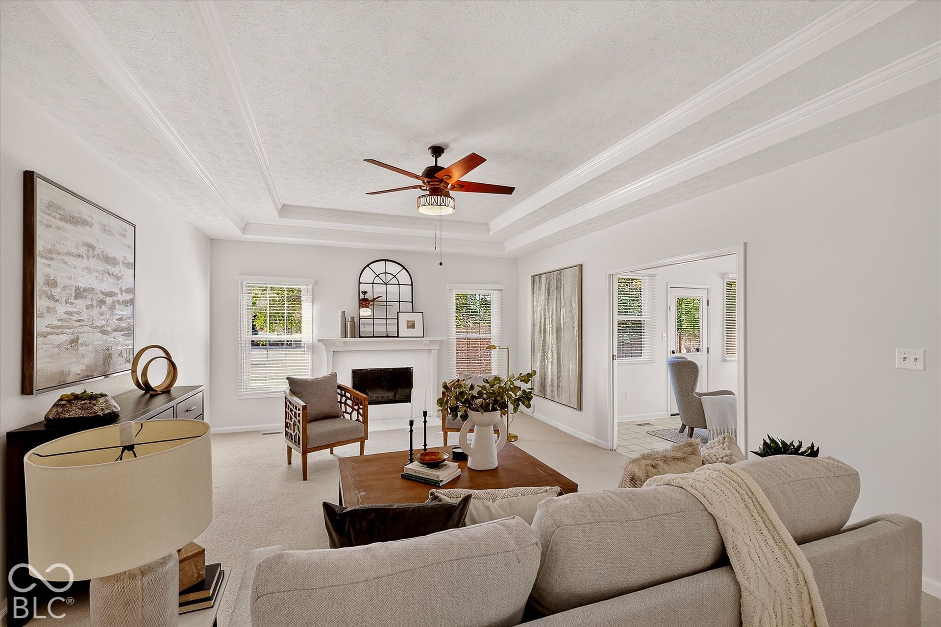 Tray ceiling with crown molding, ceiling fan, and recessed lighting