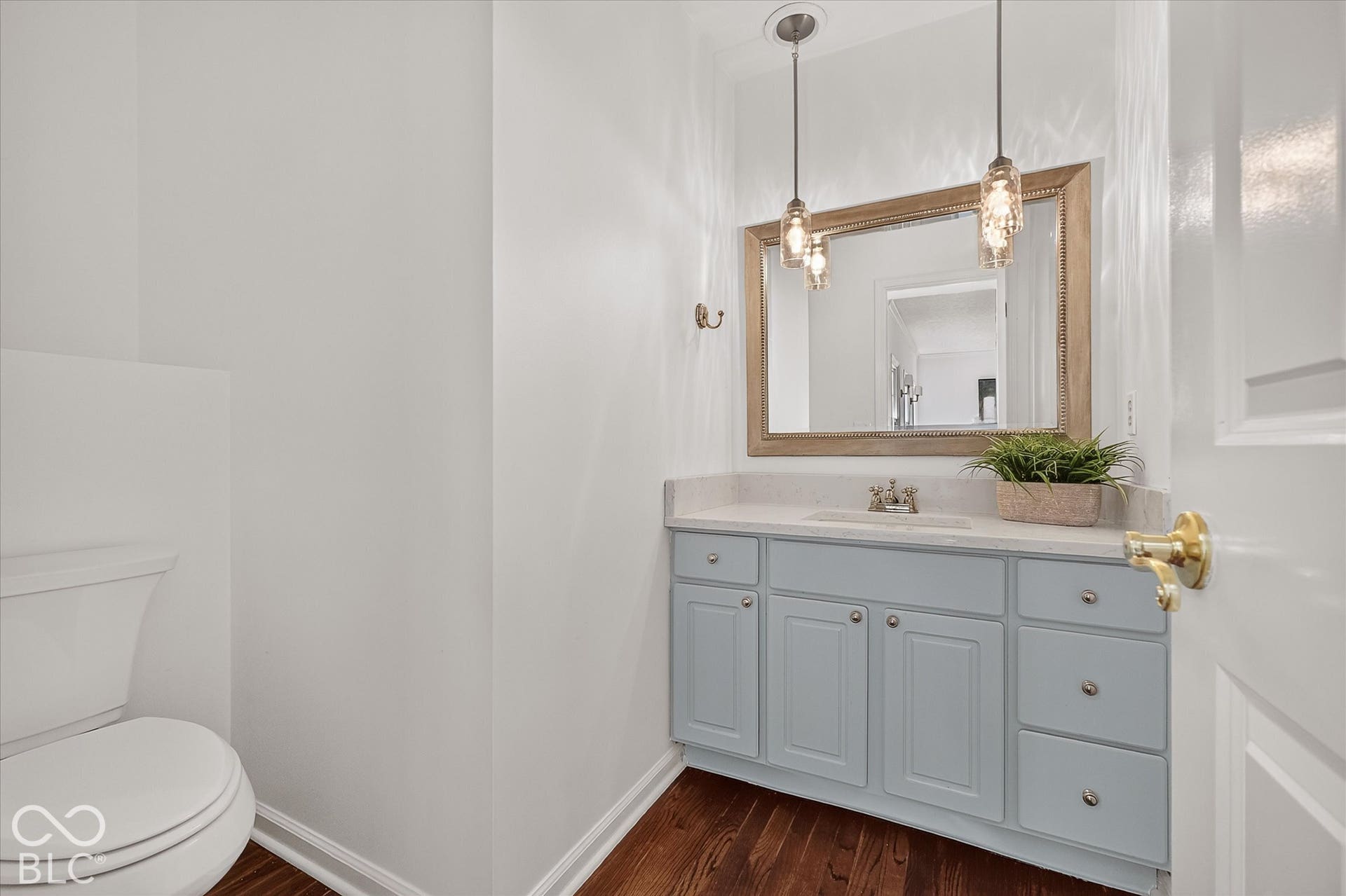 Vanity with light blue cabinetry, integrated sink, and light-toned countertop