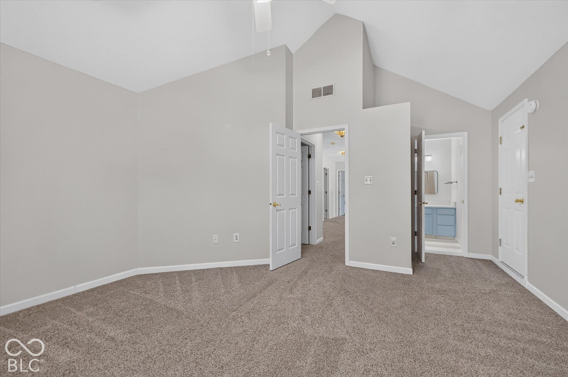 Vaulted ceilings, neutral wall color, carpeted flooring, and white trim