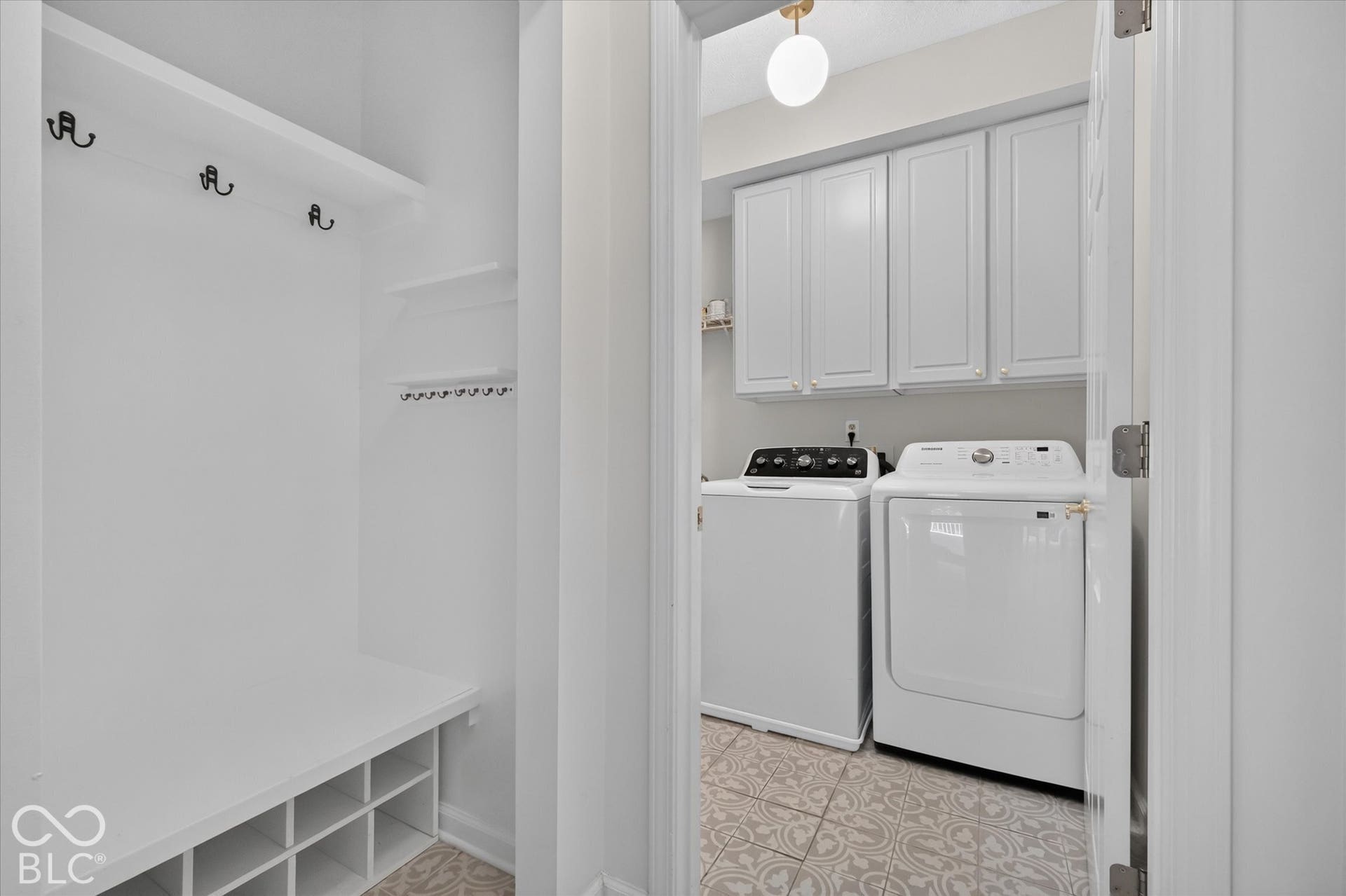 Utility area featuring built-in cabinetry, decorative floor tiling, and a built-in storage bench with hooks