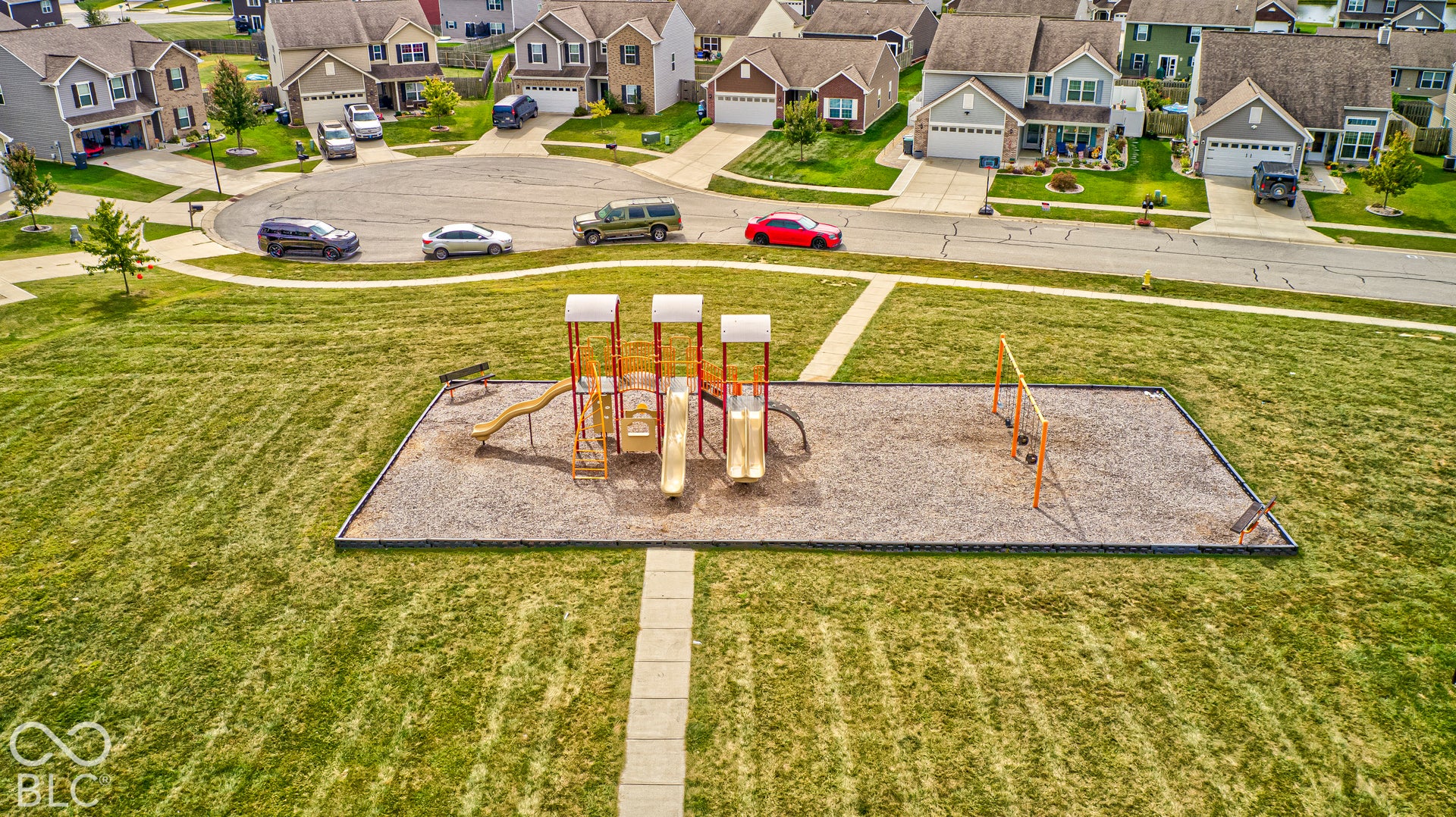Expansive green space featuring a playground with slides and swings