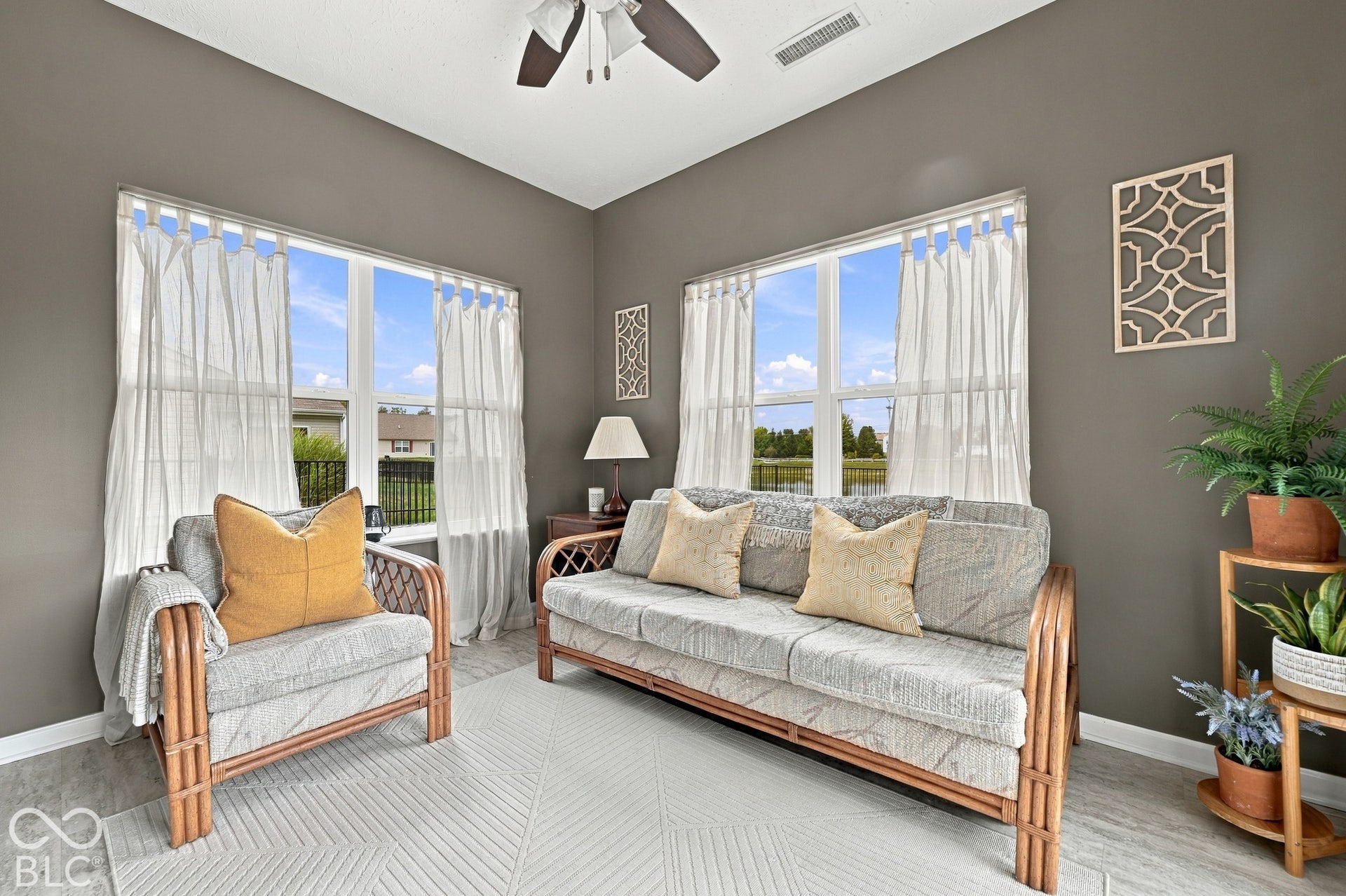 Dual windows with exterior views, featuring a ceiling fan