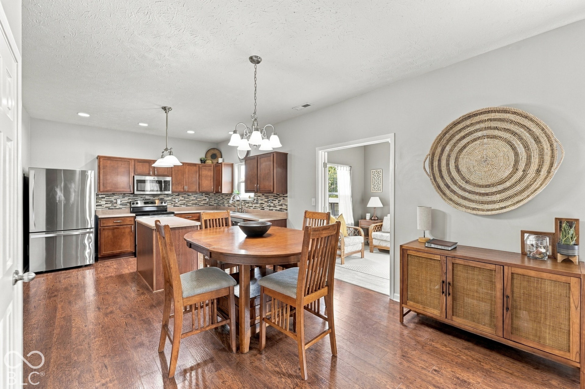 Kitchen area featuring wood-finish flooring, stainless steel appliances, a tiled backsplash, and recessed lighting