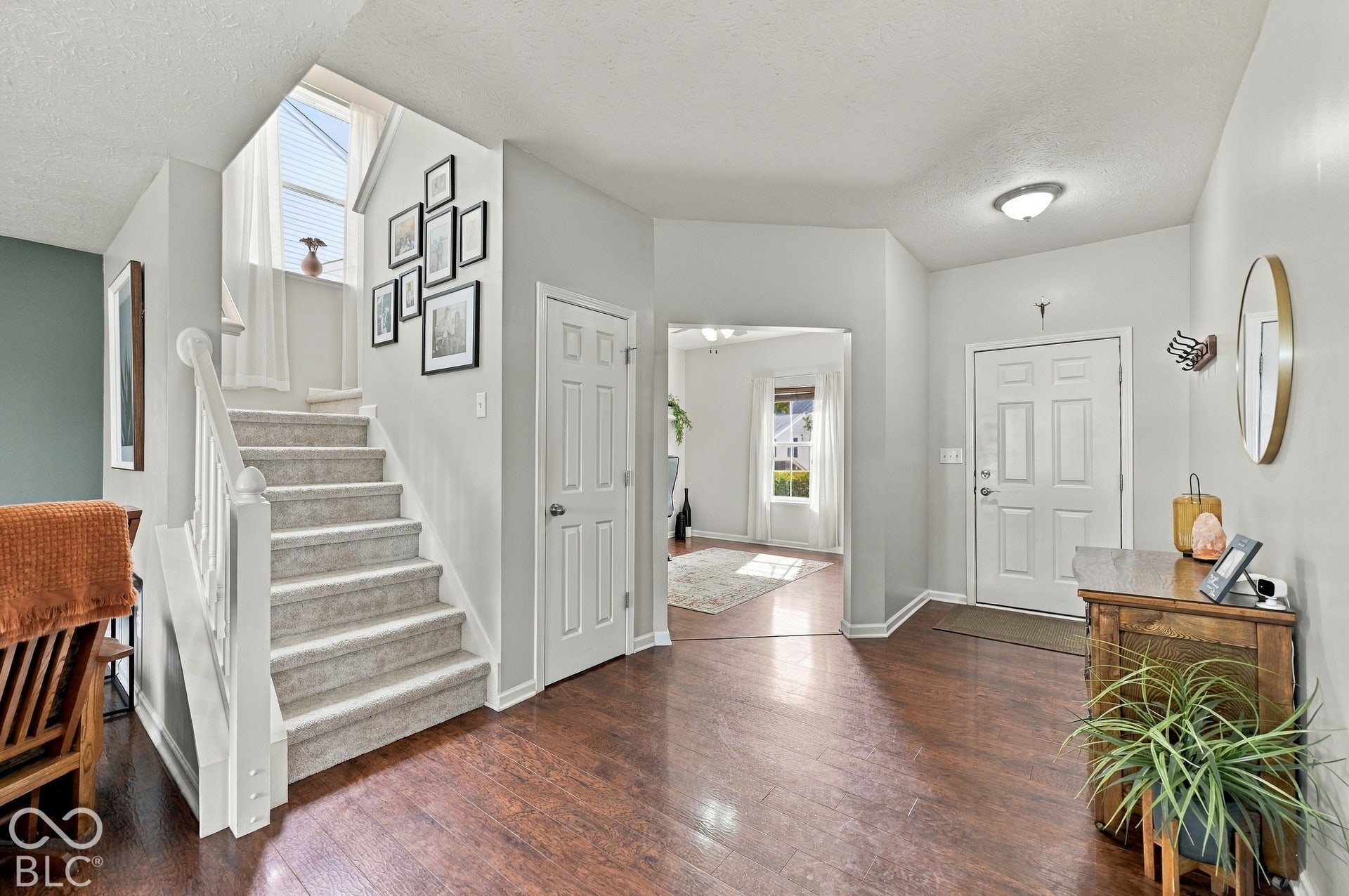 Foyer featuring wood-finish flooring, a white paneled entry door, and recessed lighting