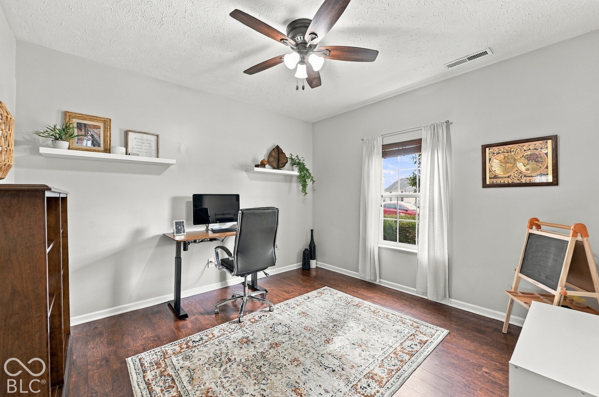 Recessed window with white trim, wood-finish flooring, ceiling fan with integrated lighting, and built-in wall shelves