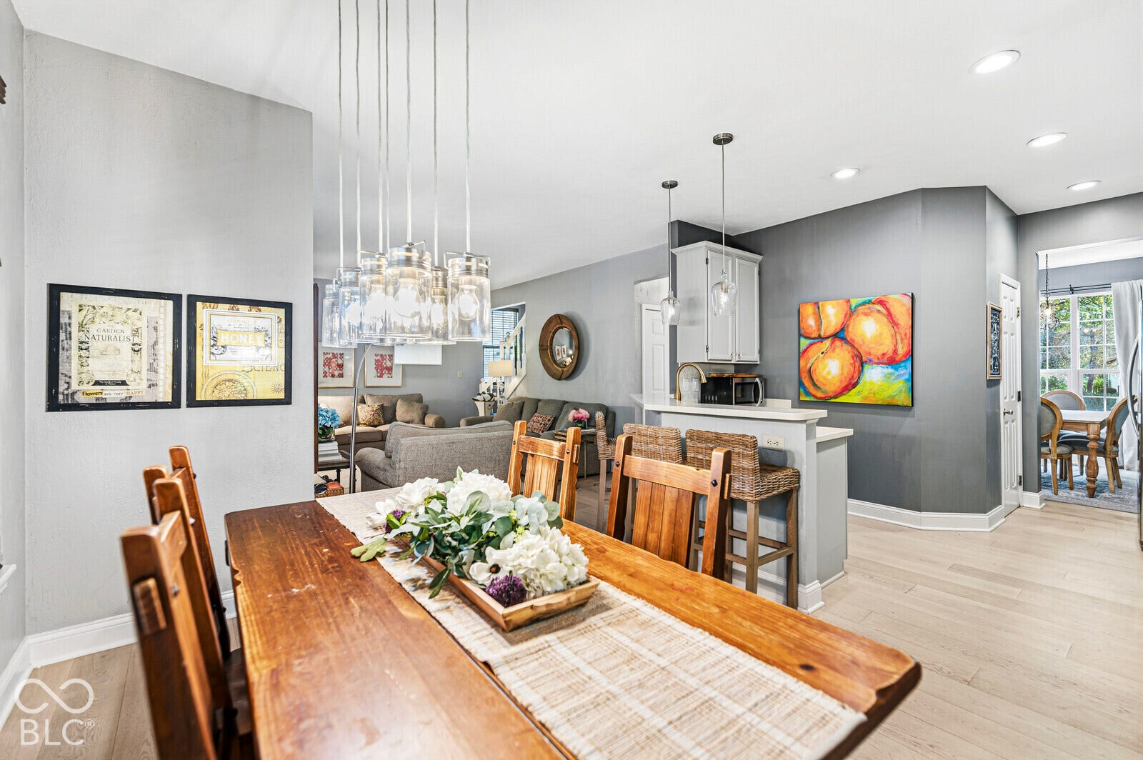 Dining area with multi-light pendant fixture, light wood-finish flooring, and recessed lighting