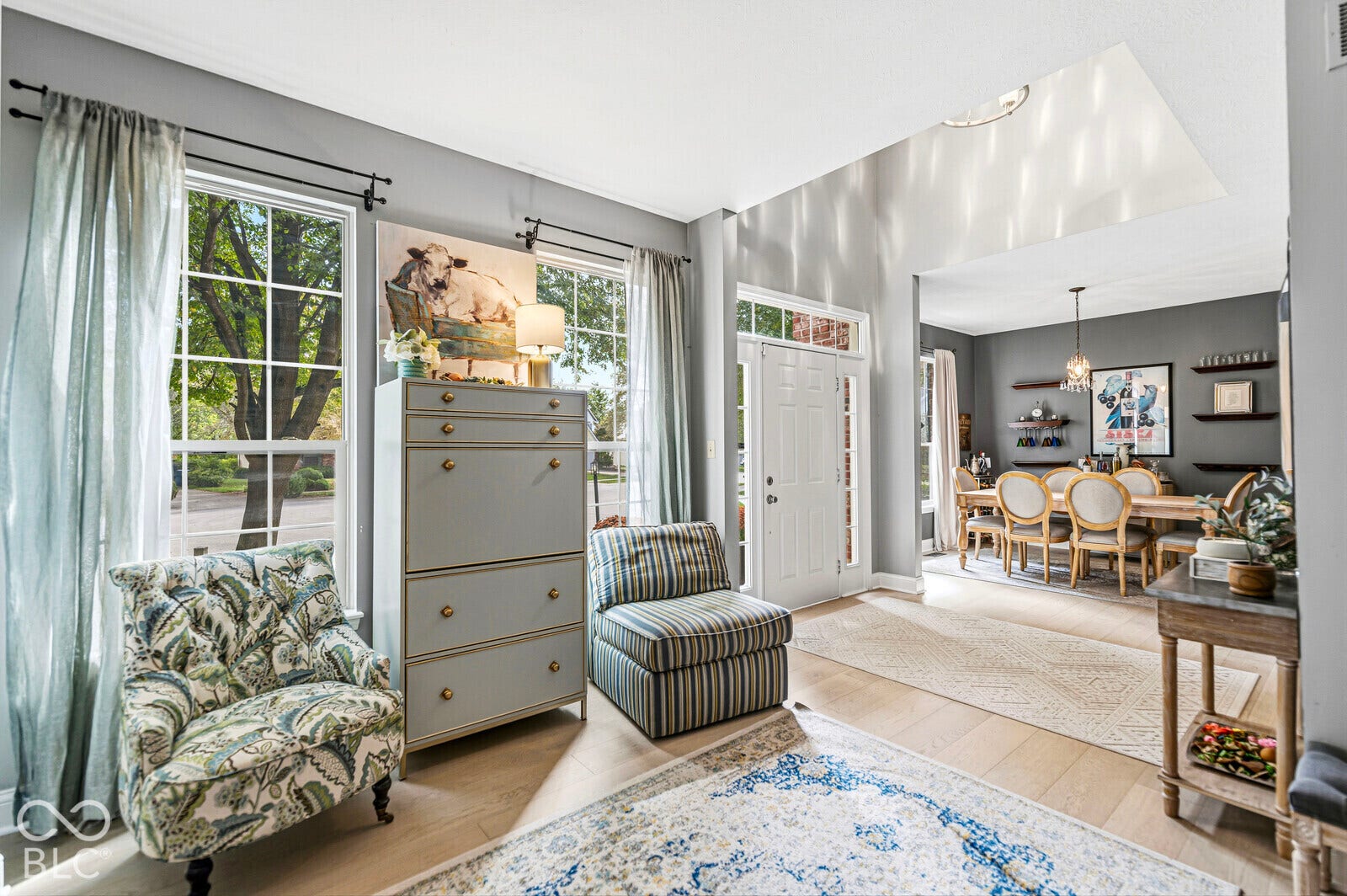 Entryway with wood-finish flooring, a white paneled front door, and transom window