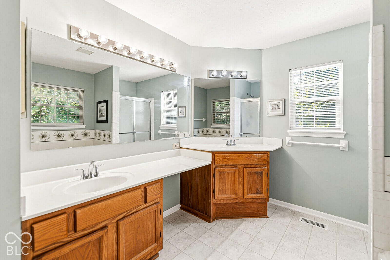Double vanity with wood cabinetry and white countertops